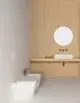 Weiße sanitäre Einrichtung in modernem Badezimmer mit Holzverkleidung. Ideal Standard Wand-Waschtischarmatur mit Kreuzgriffen über einem rechteckigen Waschbecken.